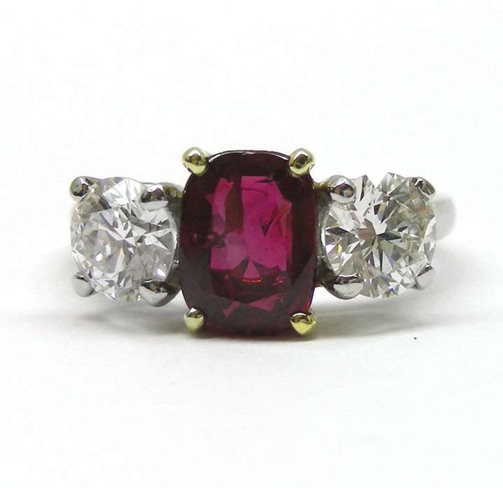 Platinum, ruby and diamond three stone ring, the central cushion-cut ruby of 1.64cts